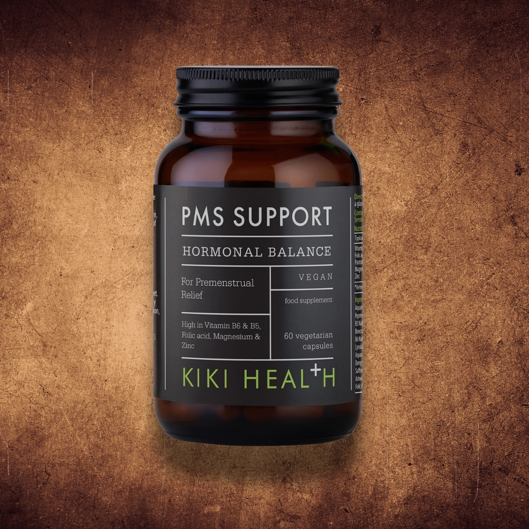 KIKI Health PMS Support capsules bottle for hormonal balance and premenstrual relief on rustic brown background