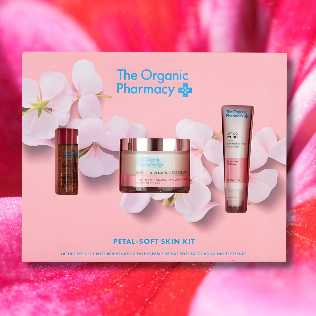 The Organic Pharmacy Petal-Soft Skin Kit luxury skincare gift set displayed against a vibrant pink petal background